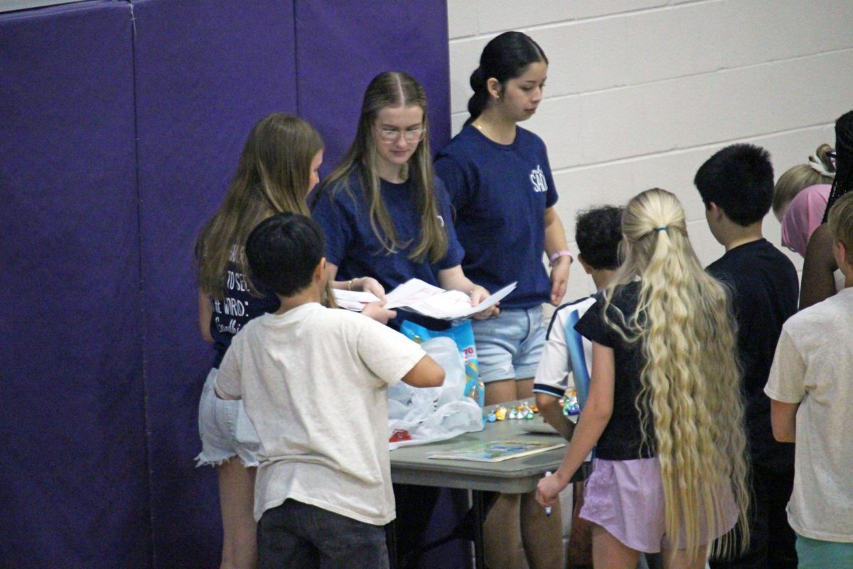Passing out papers. A trio of SADD members pick up the magazine picture ideas from the group of Anthony middle schoolers who conjured up designs to either promote good or bad products. This was made to get them thinking about what good things are to have for your body and what are bad things to have, such as water over alcohol or propaganda promoting energy drinks or cigarettes. The visit to AMS took place on Mar. 31.