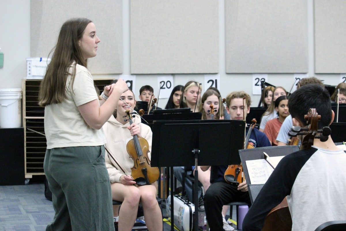 String teacher. One of the Orchestra teachers from Manhattan High School explains to the Anthony Middle School 8th grade Orchestra why there are a few new people in their ensemble today. The MHS Symphonic Orchestra is visiting the middle schools during their class time to play their music, have fun and encourage them to play their string instruments in the high school. The visit to Anthony Middle School was on Mar. 31.