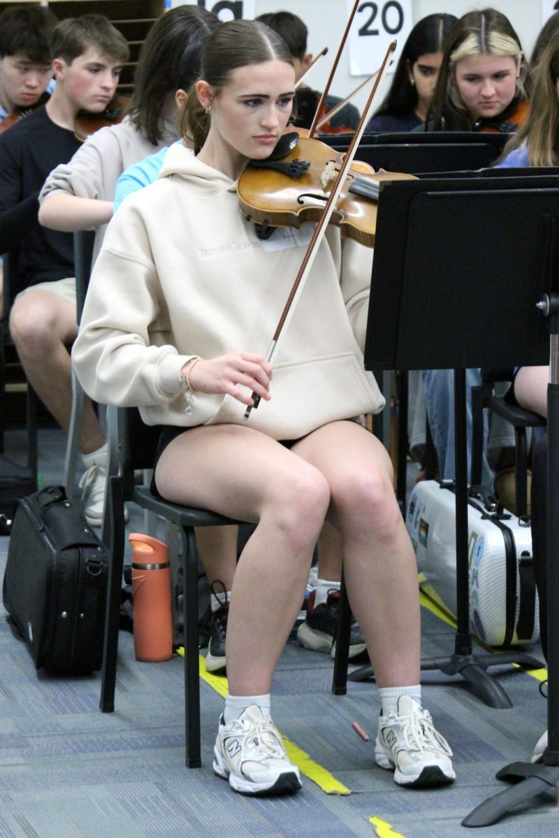 Focus on the music. Junior Natalie Blanc reads off the pages of sheet music with the Anthony Middle School 8th grade Orchestra as the Manhattan High School Symphonic Orchestra visits them. The MHS Symphonic Orchestra is visiting to encourage these young musicians to keep playing in high school for the Symphonic Orchestra. The MHS Visit to AMS was on Mar. 31, during the school day.