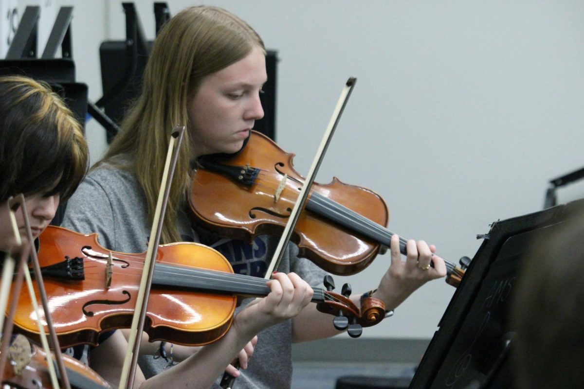Locked in. Sophomore Madi Cunninghim gets serious while she plays with the Anthony Middle School 8th grade Orchestra as the Manhattan high School Symphonic Orchestra cite reads the music. These high schoolers are visiting the middle schools to encourage them to play more in the future once they get into high school and to play in the symphonic Orchestra for more of a challenge. The ranking of the 3 MHS Orchestras are Concert Orchestra, Symphonic Orchestra and then Chamber Orchestra. 