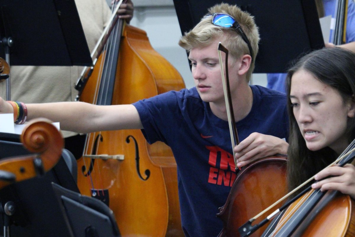 Site reading music. Sophomore Spencer Cunningham pencils in the notes and accents into the music as he plays with the Anthony Middle School Orchestra. Cunningham, with others from the Manhattan High School Symphonic Orchestra, visit the middle schools in Manhattan to talk to the 8th graders who are going into high school to tell them that they should keep playing throughout high school. This visit was on Mar. 31.