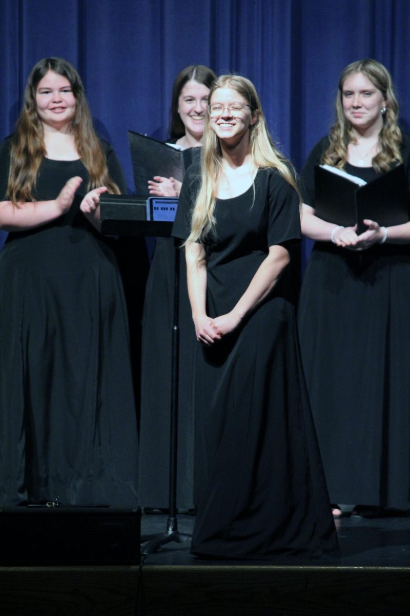 Student-made. Senior Alia Ulmer gets cheered on as she is announced onto the Rezac stage during the Final Choir Concert for the Manhattan High School Choirs on May 13. Ulmer revealed to be the composer of a chorale piece called “Flowers,” which had its premiere performed by MHS Choir members who volunteered to sing her song.