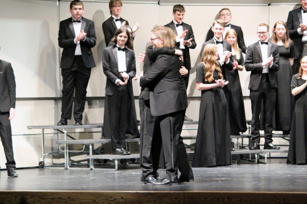 Father and son. Senior Micah Pape gives his dad, Choir Director Chad Pape, a big ‘ol hug as the gift giving ceremony speech was given. Micah Pape gave that speech during the Manhattan High school Final Choir Concert on the Rezac Auditorium stage on May 13.