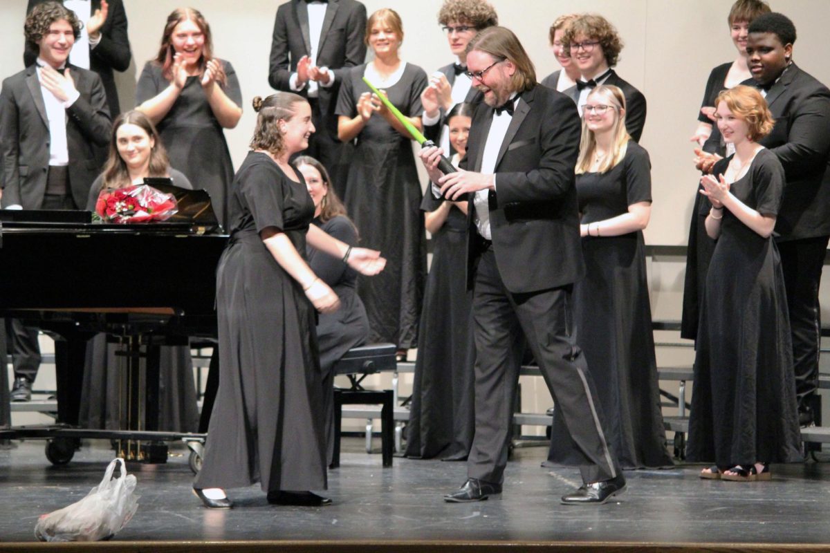 Wonderful gifts. Senior Leah Herring gives the Manhattan High School choir Director Chad Pape a green lightsaber that he states is his accurate color. This occurred during the MHS Final Choir Concert on May 13, where all the choirs at MHS perform together in one concert on Rezac Stage. 