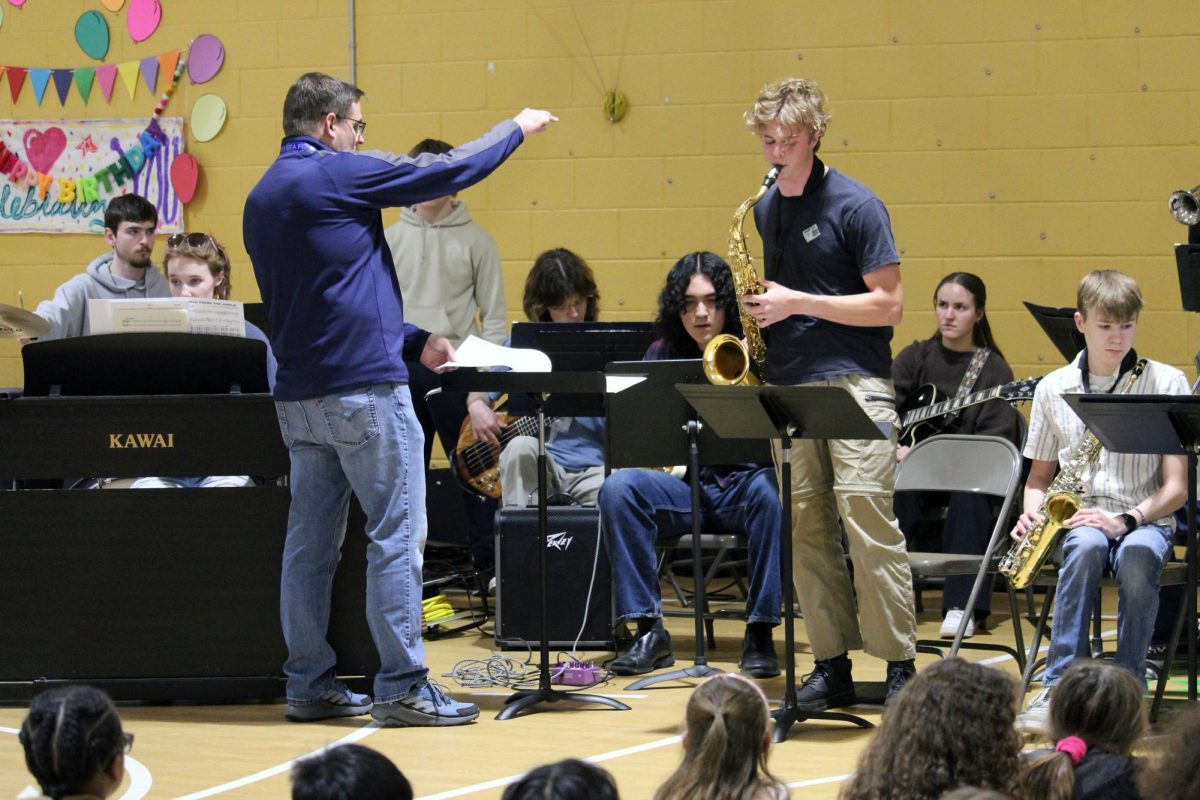 Point and play. The Manhattan High School Jazz band teacher Devin Burr cues in senior Ian Hupp for his tenor saxophone solo in one of the pieces played by the MHS Jazz Band for some elementary school students. The Blue Notes jazz band visited Ogden and Woodrow Wilson Elementary school to introduce the young kids to the fun and loud world of jazz band.