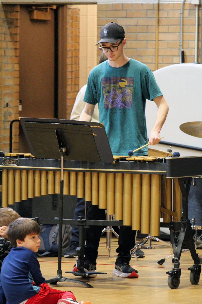 Focused in. Senior Kimball Morris whacks the percussion instrument with mallets while following the melody of the jazzy tune while playing in the MHS Blue Notes Jazz Band for Woodrow Wilson Elementary. The percussion instruments were brought to the elementary schools via truck, where they unload and reload it many times.
