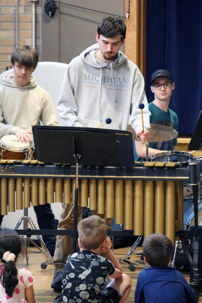 Loud music. The little elementary schoolers cover their ears from the loudness of the Manhattan High School Jazz band. Senior Ben Pittman rocks out on one of the percussion instruments the jazz players rolled in. The MHS Jazz Band visited two elementary schools on May 1, Ogden Elementary and Woodrow Wilson Elementary.